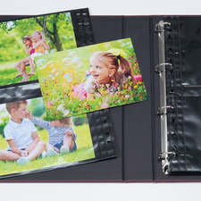 Ein Fotoalbum mit mehreren Bildern von Kindern im Freien, darunter ein Mädchen mit Blumen und ein Junge im Gras.