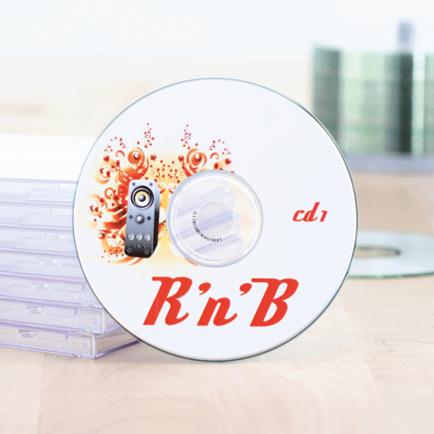 R'n'B CD mit der Aufschrift "cd 1" und einem Lautsprecher-Design, neben transparenten CD-Hüllen auf einem Holzuntergrund.