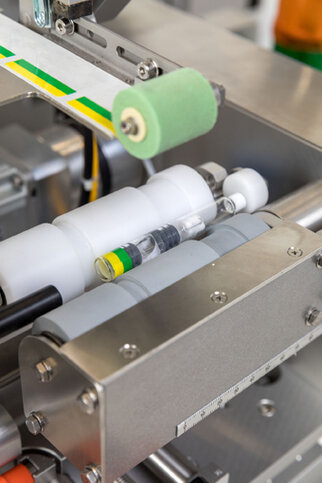 Machine parts with transparent and colored containers arranged in an industrial setting.