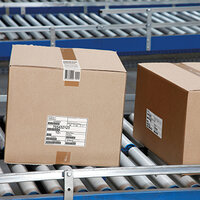 Shipping label on brown boxes, on the conveyor belt in logistics.
