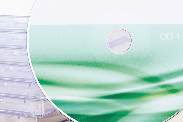 Instructions for submitting print data, CD in front of a stack of jewel cases, landscape format.