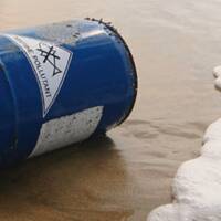 Chemical drum washed up on the shore, with a seawater-resistant label.