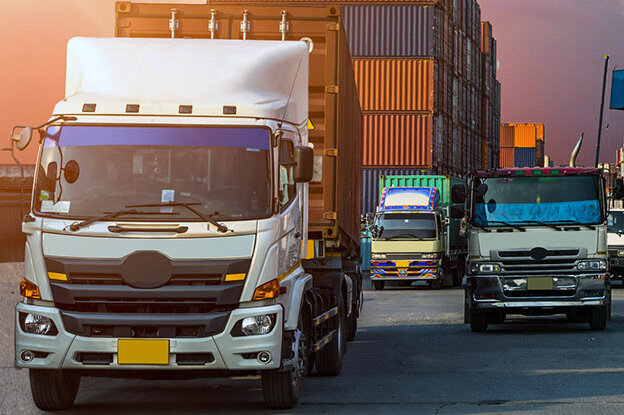 The translation of "LKWs mit Containern" is "trucks with containers.
