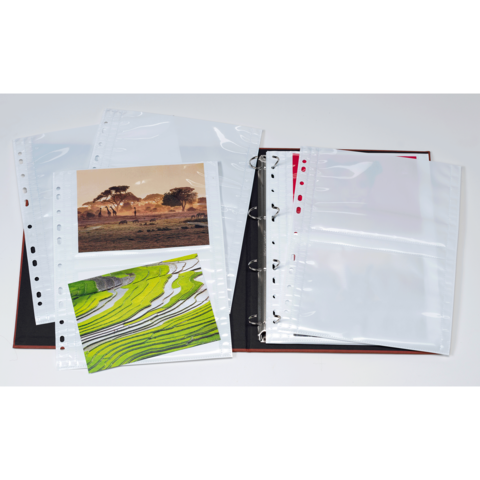 Ein Fotoalbum mit leeren Hüllen und zwei eingelegten Bildern, eines mit einer Landschaft und das andere mit grünen Feldern.