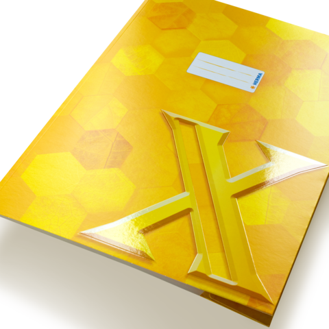 Gelbes Notizbuch mit einem hexagonalen Muster und einem großen, glänzenden, gelben "X" auf der Vorderseite. Ein Etikett ist sichtbar.
