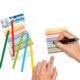Bunte Stifte liegen neben einem Blatt, auf dem mit einem Stift geschrieben wird. Farbkarten sind ebenfalls sichtbar.