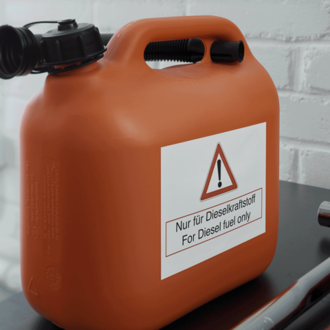 Oranger Kanister mit Warnschild, das anzeigt, dass er nur für Diesel-Kraftstoff verwendet werden darf.