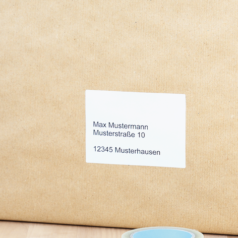 Blaue Kunststoffbox mit einer Etikette, die die Nummer 0134 zeigt, steht auf einem Tisch neben einem Notizblock und einem Stift.