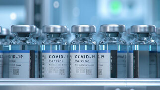 COVID-19 vaccine vials lined up, each with a label indicating the ingredients and dosage.