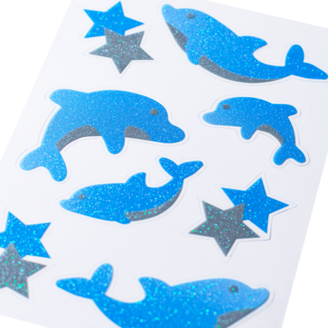 Blue glitter stickers in the shape of dolphins and stars on a white background.