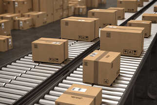 Cartons on a conveyor belt in a warehouse, ready for shipping. The packages are neatly arranged and labeled.
