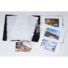 Ein Fotoalbum mit leeren Klarsichthüllen und mehreren Bildern von Landschaften und Städten, die darin eingelegt sind.