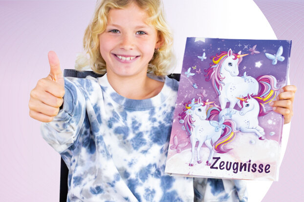 A girl gives a thumbs up and smiles while holding a colorful binder with a unicorn design and blank pages.