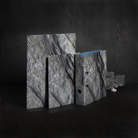 Drei Platten aus grauem Stein in unterschiedlichen Größen, eine mit einer blauen Kante, auf einem dunklen Hintergrund.