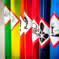 Hazard labels on colored containers in the chemical industry