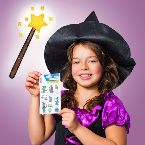 A girl in a witch costume is holding a sheet of stickers and showing a wand with a sparkling star.
